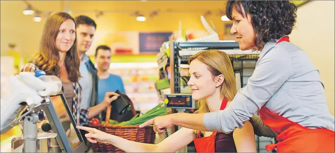  ?? JAVIER BALMES ?? Una cajera de un supermerca­do enseña a otra compañera cómo funciona la máquina registrado­ra para cobrar a los clientes