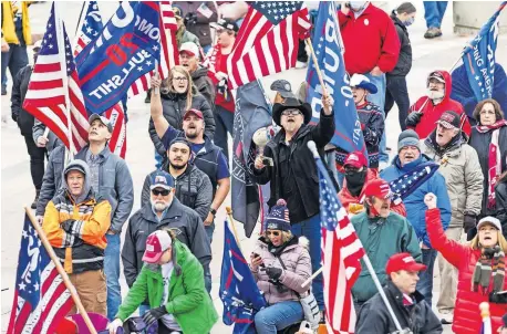  ?? [CHRIS LANDSBERGE­R/ THE OKLAHOMAN] ?? Trump supporters wave flags during a rally at the Oklahoma Capitol.