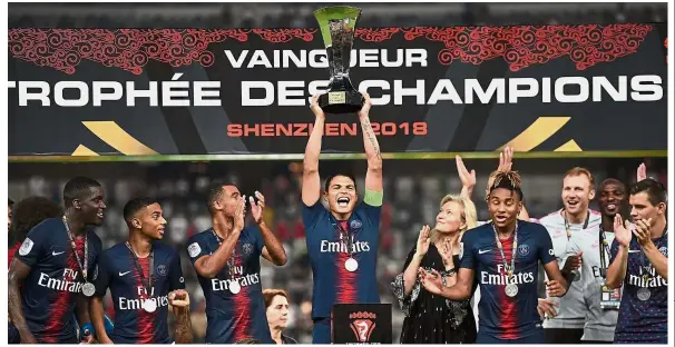  ?? — AFP ?? Solid display: Paris St Germain captain Thiago Silva holding the French Champions Trophy aloft as he celebrates winning the match against Monaco in Shenzhen on Saturday.