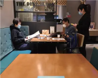  ??  ?? A couple orders food at a restaurant in Joy City, a shopping mall in Chaoyang District, Beijing, on March 23. With the epidemic under control in China, restaurant­s have been reopening gradually with measures in place