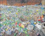  ?? PTI ?? A woman sits among plastic bottles segregated for recycling.