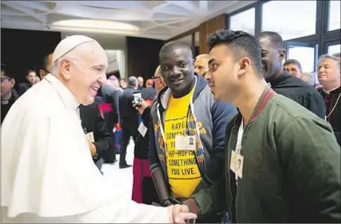  ?? CNS ?? El Papa Francisco saluda a dos jóvenes durante el Sínodo de los obispos en el aula sinodal del Vaticano