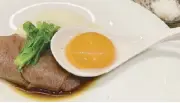  ?? ?? One of Japan’s best beefs: Hitachi Wagyu beef is layered over a sweet-savory sauce and served with egg foam and golden egg yolk in Kazunori’s deconstruc­ted rendition of sukiyaki.