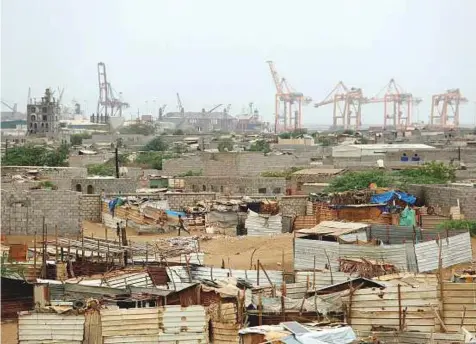  ?? Reuters ?? Hodeida port’s cranes rise above a nearby shantytown. The port is a lifeline for millions of Yemenis, as most of the commercial imports and relief supplies enter through it to the country.