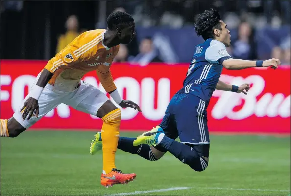  ?? — THE CANADIAN PRESS FILES ?? Vancouver Whitecaps’ Masato Kudo, right, is apparently tripped-up by Houston Dynamo’s Jalil Anibaba during the first half in Vancouver last week. The move cost Houston a penalty and Vancouver went on to win the game.