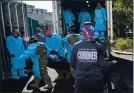  ?? L.A. COUNTY DEPT. OF MEDICAL EXAMINER-CORONER VIA AP ?? National Guardsmen help place bodies of COVID-19 victims into storage at the Los Angeles County coroner’s office on Jan. 12.