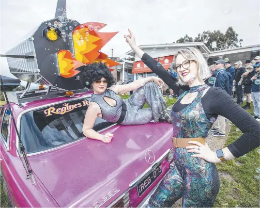  ?? Picture: Eddie Safarik ?? Saga Hassinen (black wig) and Sarah Stone get into the disco vibe for the launch of TasBash with a 1973 Mercedes.