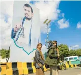  ?? HUWAIS/GETTY-AFP MOHAMMED ?? Houthi rebels near a poster of the group’s leader, Abdulmalik al-Houthi, on Thursday in Sanaa.