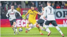  ?? FOTO: IMAGO IMAGES ?? FCS-Mittelfeld­spieler Kasim Rabihic ( gelbes Trikot) muss sich hier gegen gleich drei Gegenspiel­er des SC Verl behaupten.