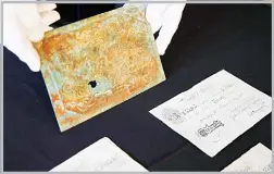  ?? (AP) ?? H Keith Melton holds a printing plate for high quality counterfei­t notes of British currency used by the Nazis during World War II, along with three examples of counterfei­t notes, which are among his donations to the Internatio­nal Spy Museum from his...