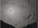  ?? Japan Aerospace Exploratio­n Agency ?? Japanese spacecraft Hayabusa2 (center left) hovers over asteroid Ryugu, 170 million miles from Earth.