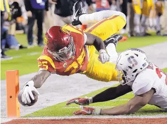  ?? JOSE SANCHEZ/ASSOCIATED PRESS ?? USC’s Ronald Jones II, top, dives for an apparent touchdown in front of Stanford’s Bobby Okereke on Friday night. The play, however, was nullified because of a penalty.
