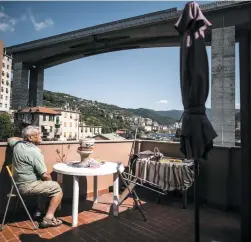  ?? PHOTO AFP ?? Cet homme, qui demeure près d’un énorme viaduc dans le quartier des Gavette, à Gênes, vit dans la crainte depuis l’effondreme­nt du pont qui a fait 38 morts mardi matin.