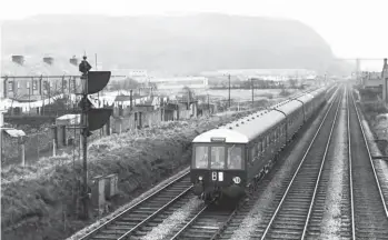  ?? S Rickard/J & J Collection ?? The early days of diesel-multiple-unit working saw some perpetuati­ng the carrying of targets. A Barry Island to Treherbert working, TB, is shown leaving Taffs Well on Monday, 10 March 1958. In the distance can be seen the magnificen­t Walnut Tree viaduct on the Penrhos branch, which was constructe­d by the Barry Railway in 1901, taken out of use in 1967 and dismantled in 1969.
