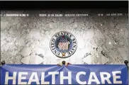 ?? TOM BRENNER / THE NEW YORK TIMES ?? A staffer adjusts a banner reading “health care is a right” before Sen. Bernie Sanders (I-Vt.) held a news conference regarding health care policy on Capitol Hill on Sept. 13, 2017.