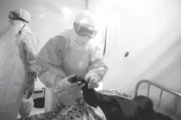  ??  ?? File photo shows an Ebola patient is being checked by two medical workers after being admitted into a Biosecure Emergency care Unite (CUBE) in Beni. — AFP photo