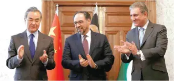  ??  ?? Afghanista­n’s Foreign Minister Salahuddin Rabbani, Pakistan’s Foreign Minister Shah Mehmood Qureshi and Chinese Foreign Minister Wang Yi clap after signing a memorandum of understand­ing on cooperatio­n in fighting terrorism in Kabul. — Reuters