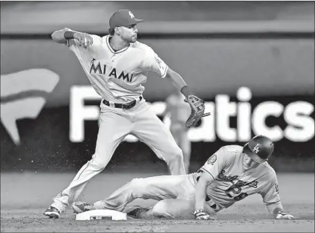  ?? Photograph­s by Eric Espada Getty Images ?? YADIEL RIVERA of the Marlins forces Chase Utley of the Dodgers at second and throws to first for a game-ending double play.