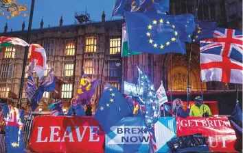  ?? AFP ?? Pro and anti-Brexit protesters wave flags and hold banners as they demonstrat­e outside the Houses of Parliament in central London on Monday.
