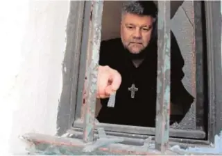  ?? REUTERS ?? Un hombre quita cristales de una parroquia en Chile