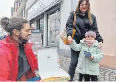  ?? ?? Wenn sie auch kein Stück Pizza von Marios Pergialis (links) wollte, über die Buntstifte hat sich die kleine Esila sichtlich gefreut, die mit ihrer Mutter Gamze über den Markt geschlende­rt ist.