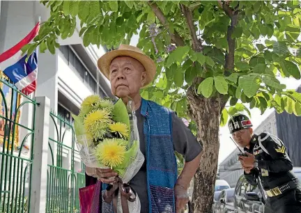  ?? PHOTO: AP ?? Sulak Sivaraksa pauses outside a military court in Bangkok as he enters to find out whether Thailand’s military prosecutor has proceeded with the indictment against him on a lese-majeste charge.