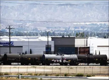  ?? WATCHARA PHOMICINDA ?? A rail car that officials say is leaking a toxic substance sits on the tracks near the intersecti­on of Harvill and Old Oleander Avenues just west of the 215Freeway near Perris on Friday. The hazmat incident is forcing area residents to evacuate and freeway and road closures.