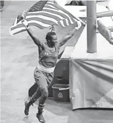  ?? ERICH SCHLEGEL, USA TODAY SPORTS ?? Boxer Claressa Shields carries a U.S. flag as she runs around the ring Sunday celebratin­g her gold medal victory.