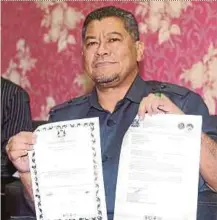  ??  ?? Johor Housing and Rural Developmen­t Committee chairman Dzulkefly Ahmad showing the falsified certificat­es to buy affordable homes in Taman Perniagaan Setia II in Johor Baru recently.