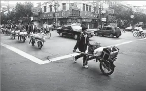  ?? ZHONG NAN / FOR CHINA DAILY ?? Migrant workers from East China’s Anhui province walk along Nanjing Road in Shanghai in March, 1983.