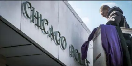  ?? ANNIE COSTABILE — CHICAGO SUN-TIMES VIA AP ?? Photo from video of a worker hanging purple and black bunting outside Chicago Police District 2 Wentworth headquarte­rs in Chicago, Tuesday in memory of slain Chicago Police Officer Samuel Jimenez. Jimenez was killed during Monday’s shooting at Mercy Hospital in Chicago.