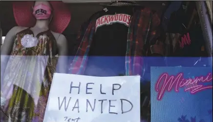  ?? ASSOCIATED PRESS ?? In this Jan. 7 file photo, a “Help Wanted,” sign is shown in the window of a souvenir shop in Miami Beach, Fla.