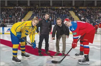  ??  ?? Team Sweden defenceman Erik Brannstrom, left, and Team Russia forward Vitalii Kravtsov participat­e in a ceremonial puck-drop at Prospera Place in Kelowna on Tuesday night prior to their World Junior Championsh­ip pre-tournament game, which Sweden won 4-2. The WJC tournament begins Boxing Day in Vancouver and Victoria and runs through Jan. 5.