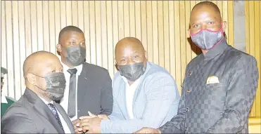  ?? (File pic) ?? Hosea MP Mduduzi Bacede Mabuza (R) and his coaccused, Ngwempisi MP Mthandeni Dube, looking at their supporters before having a moment with Sicelo Mngomezulu (L), who forms part of their defence team.