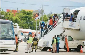  ?? ODELYN JOSEPH/AP ?? Haitians who were deported from the United States disembark Sept. 19, 2021, at the Toussaint L’Ouverture Internatio­nal Airport in Port au Prince, Haiti. More than 20,000 Haitians have been deported from the U.S. in the past year.