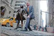  ?? BEBETO MATTHEWS/AP PHOTO ?? New York Mayor Bill de Blasio poses with the “Fearless Girl” statue on Monday. De Blasio says the popular statue will be allowed to remain through February 2018.