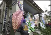  ?? JANET MCCONNAUGH­EY — THE ASSOCIATED PRESS ?? Parade float workers Travis Keene, left, and Joey Mercer position a pelican while fellow crew member Chelsea Kamm, right, looks on while decorating a house in New Orleans on Friday.