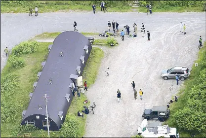  ?? AP ?? Japanese journalist­s take photos of the building where Yamato was found.