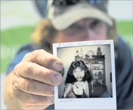  ?? RANDY VAZQUEZ — STAFF PHOTOGRAPH­ER ?? Victor Hayes, a survivor of the East Area Rapist, holds up a picture of himself at age 21 during an interview in Carmichael in June.