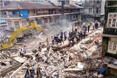  ??  ?? Firefighte­rs and rescue workers search for survivors at the site of the collapsed building in Mumbai yesterday.