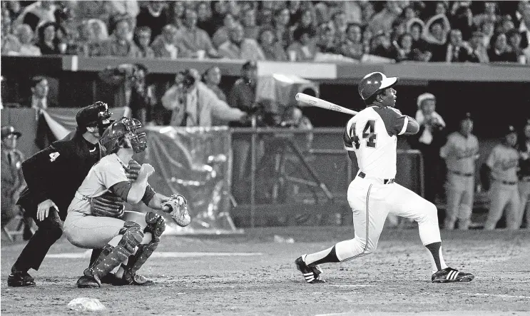  ?? AP ?? Hank Aaron eclipses the legendary Babe Ruth’s iconic Major League Baseball record for career home runs as he hits his 715th off Los Angeles Dodgers pitcher Al Downing in 1974.