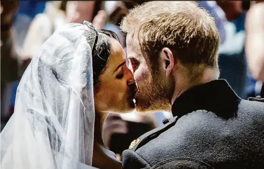  ??  ?? O primeiro beijo do príncipe Harry e Meghan Markle, o novo casal real, foi nos degraus da capela de São Jorge, ao fim da cerimônia