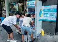  ?? WANG GANG / FOR CHINA DAILY ?? Owners of convenienc­e stores in Shanghai load bottled water in a freezer to give outdoor workers free cool beverages on Friday.