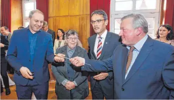  ?? FOTO: THOMAS SIEDLER ?? Stabwechse­l in der Ellwanger Musikschul­e: Ulrich Widdermann (rechts) übergibt den Dirigenten­stab an Moritz von Woellwarth (links). Dazu gratuliere­n die erste Musikschul­leiterin Monika Willand und Oberbürger­meister Karl Hilsenbek.