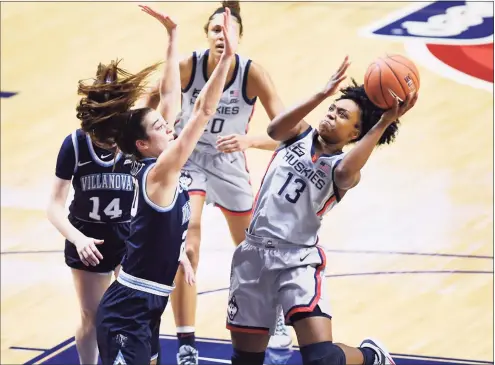  ?? Jessica Hill / Associated Press ?? UConn’s Christyn Williams, right, goes up for a basket as Villanova’s Maddy Siegrist, front left, defends during their Big East Tournament semifinal game Sunday at Mohegan Sun Arena in Uncasville.