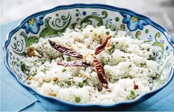  ?? ANDREW RUSH Pittsburgh Post-Gazette/TNS ?? Coconut rice is first cooked in coconut milk, along with green peas, and then flavored with grated coconut, mustard seeds, white lentils and fennel seeds. It is finished with a sprinkling of fried onions.