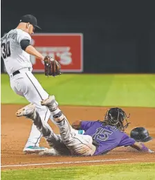  ?? Norm Hall, Getty Images ?? Rockies right fielder Raimel Tapia reaches first base the hard way on a single ahead of Arizona pitcher T.J. McFarland during the sixth inning Tuesday night at Chase Field.