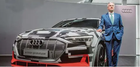  ?? Foto: Armin Weigel, dpa ?? Kaum zu glauben, aber Audi Chef Rupert Stadler steht hier neben einem Elektroaut­o. Der Audi e tron soll Ende dieses Jahres auf den Markt kommen. Mit Fahrzeugen wie die sen will Audi in die Zukunft gehen.