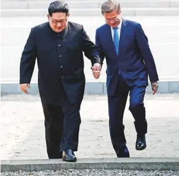  ?? Bloomberg ?? Kim and Moon cross the Military Demarcatio­n Line to the southern side of the border at the village of Panmunjom in the demilitari­sed zone in Paju yesterday. Kim became the first North Korean leader to enter the South since the peninsula was divided...