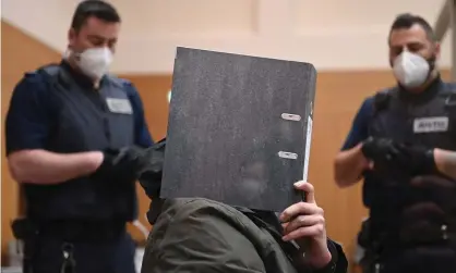  ??  ?? A defendant hides his face as he sits in the courtroom at Stammheim prison in Stuttgart. Photograph: Getty Images
